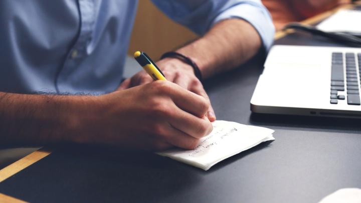 Person writing on a notepad