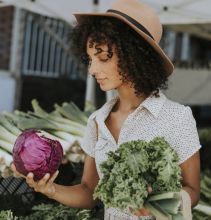 lady choosing vegetables at farmers' market