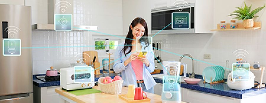 Woman in kitchen, surrounded by IoT appliances