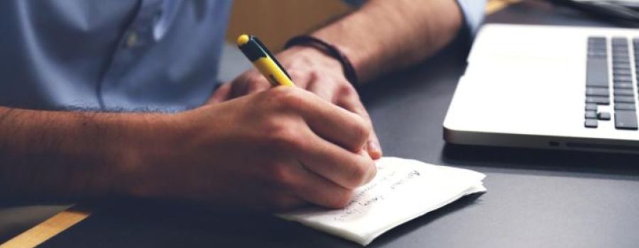 Person writing on a notepad